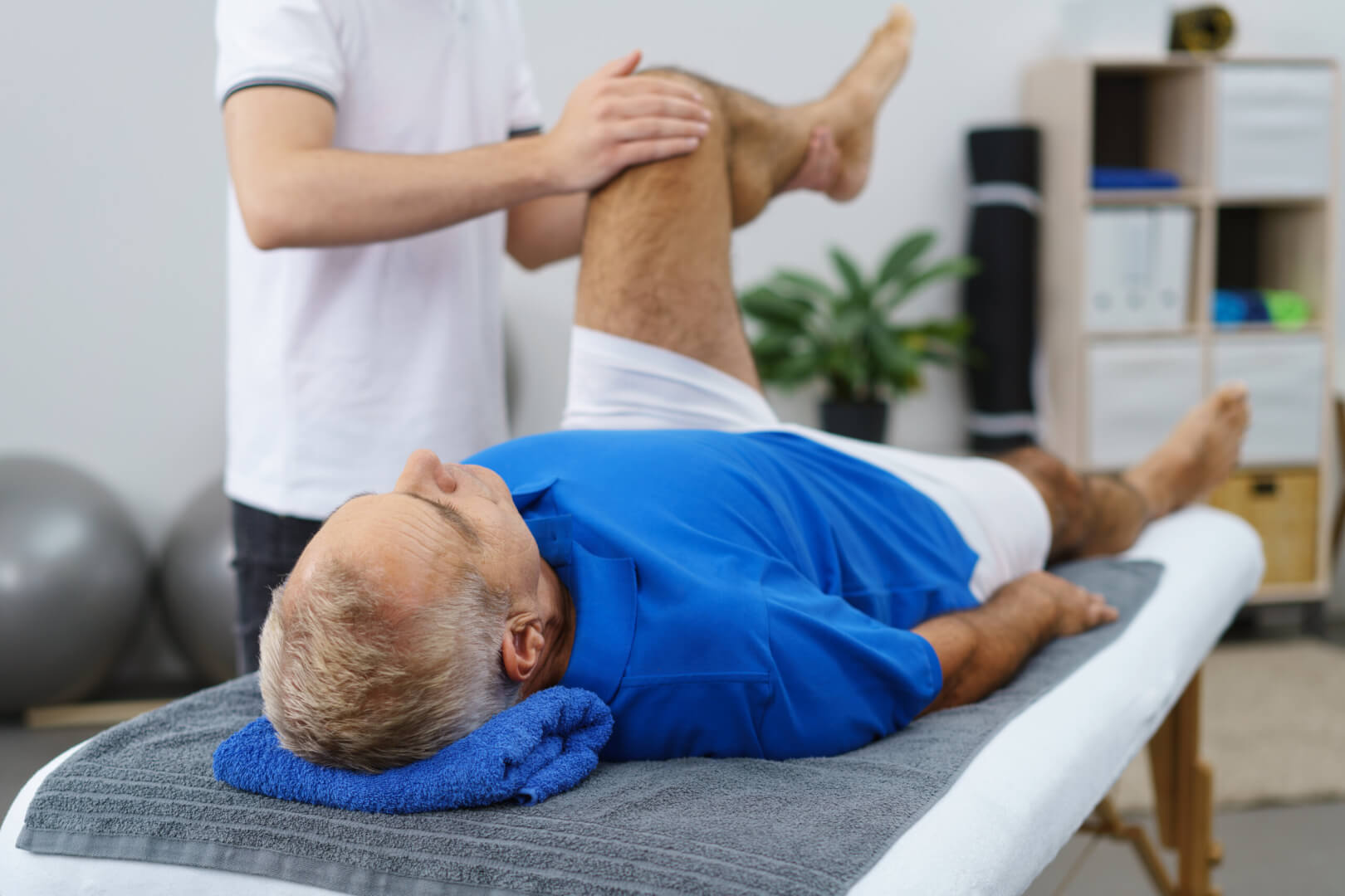 Un especialista realiza fisioterapia a una persona mayor en su domicilio