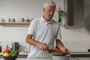 Abuelo cocinando verduras para alargar sus telómeros
