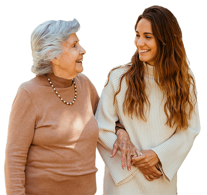 Una imagen sin fondo de una cuidadora cogiendo del brazo a una mujer mayor mientras se miran sonriendo.