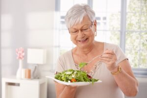 Mujer mayor siguiendo la Dieta Keto: se come una ensalada