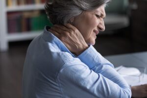 Mujer mayor siente dolores en el cuello por la fibromialgia