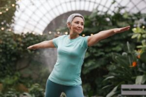 Mujer madura realizando ejercicio con los brazos estirados para evitar la pérdida de masa muscular