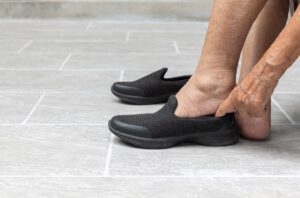 Anciana poniéndose calzado para personas mayores