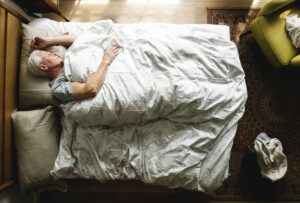 Plano cenital de un anciano caucásico durmiendo en una cama