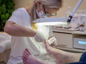 Mujer mayor acude al podólogo para tratarse las verrugas en los pies