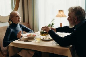 Una pareja de edad avanzada sentados en la mesa. Consumir proteína es importante en la tercera edad