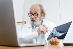 Médico de edad avanzada muestra una radiografía de un pie