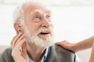 Hombre mayor con un audífono en el oído derecho
