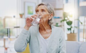 Mujer de edad avanzada bebiendo un vaso de agua